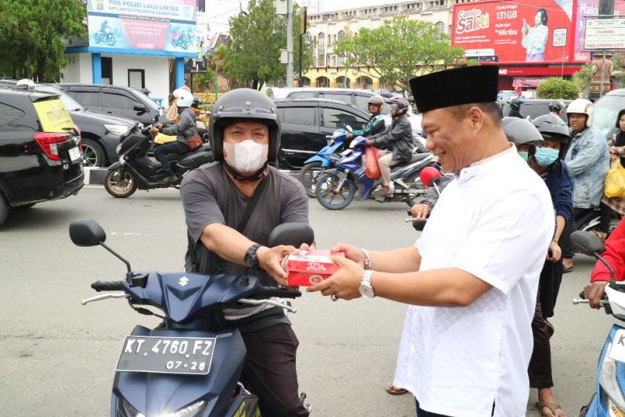 Rusianto Kiang sedang membagi takjil berbuka puasa kepada masyarakat kota Samarinda