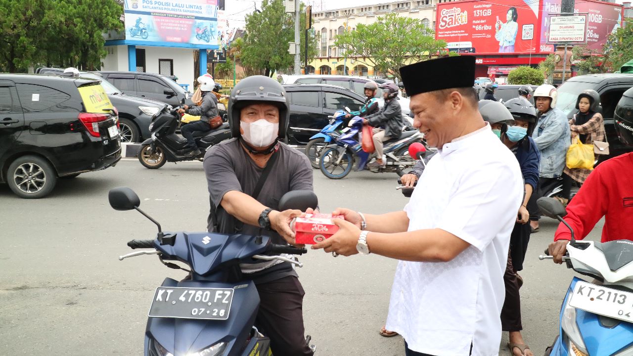 Rusianto Kiang sedang membagi takjil berbuka puasa kepada masyarakat kota Samarinda