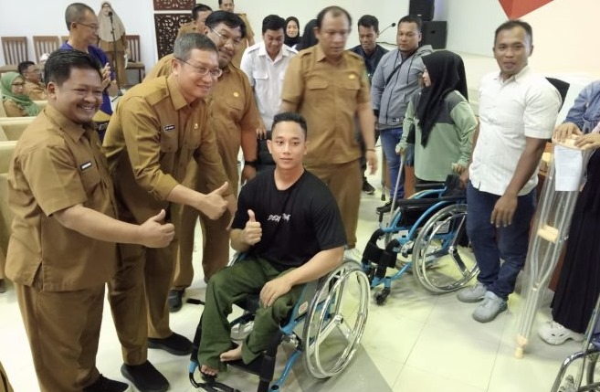Kepala Dispora Kukar, Aji Ali Husni saat menyerahkan bantuan kepada atlet Paralympic. (Foto/ist)